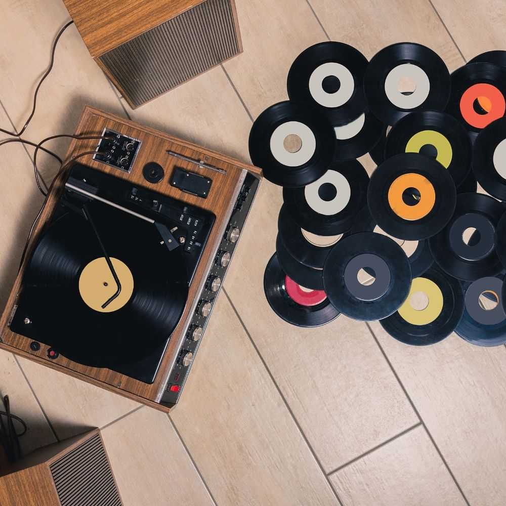 Turntable with vinyl records scattered on the floor.